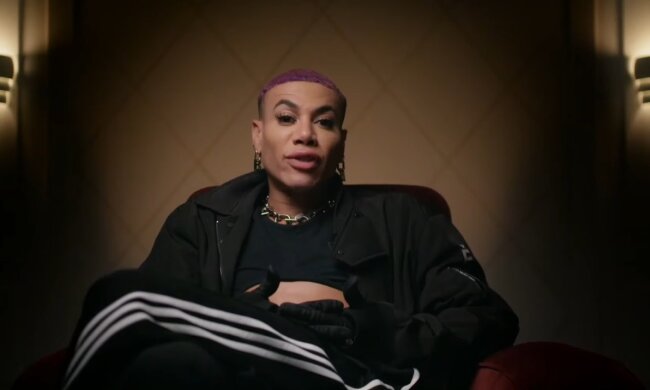 Der Mann mit den Lila Haaren und dem Grellem Make-up. Quelle: Youtube Screenshot