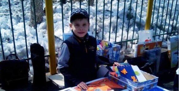 Ein freundlicher Schüler verkauft hausgemachte Postkarten und gibt den Erlös an Tierheime