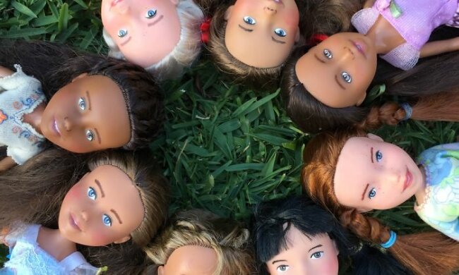 Das Mädchen zeichnet realistische Gesichter auf alte Puppen und entwickelt Charaktere für sie