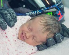 Ein neugeborenes Mädchen lächelt im Schlaf in der "Umarmung" ihres die Welt verlassenen Vaters