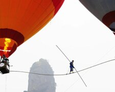 Am Rande: Akrobat zwischen zwei Luftballons