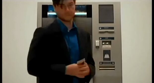 Ein Mann hebt Geld aus einem Automaten ab. Quelle: Youtube Screenshot