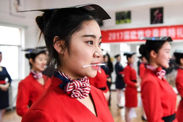Warum werden chinesische Stewardessen gelehrt, zu lächeln, zu laufen, zu stehen und zu sitzen