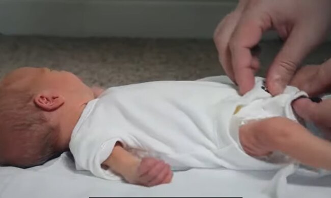 Mutter wechselt die Windeln ihres Babys im Café. Quelle: Youtube Screenshot